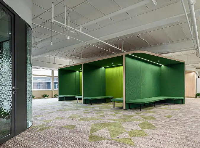 public space with green seating areas echoed in carpet tile flooring