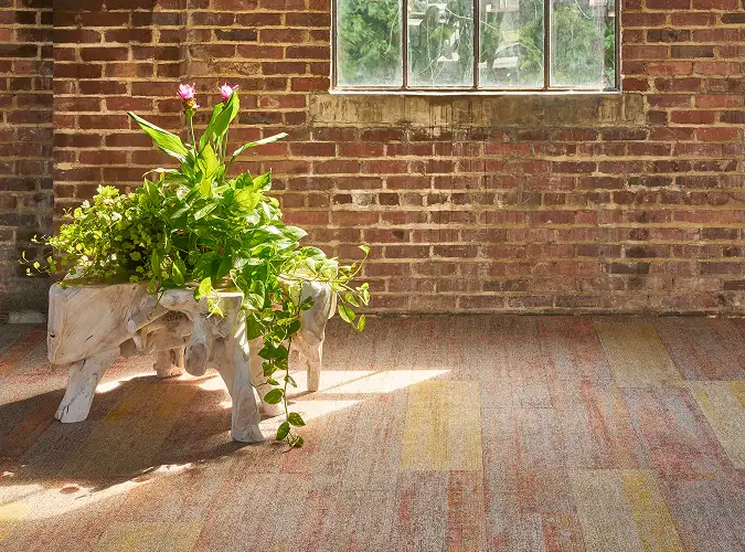 interior with an exposed brick wall and a textural plank carpet installation
