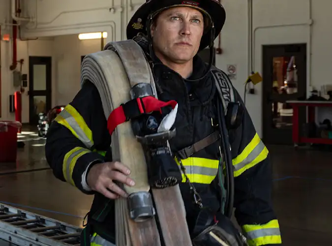 Firefighter in station wearing Milliken Flame Resistant Fabrics