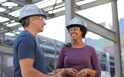 Manufacturing leaders engaged in a group problem-solving session on the plant floor
