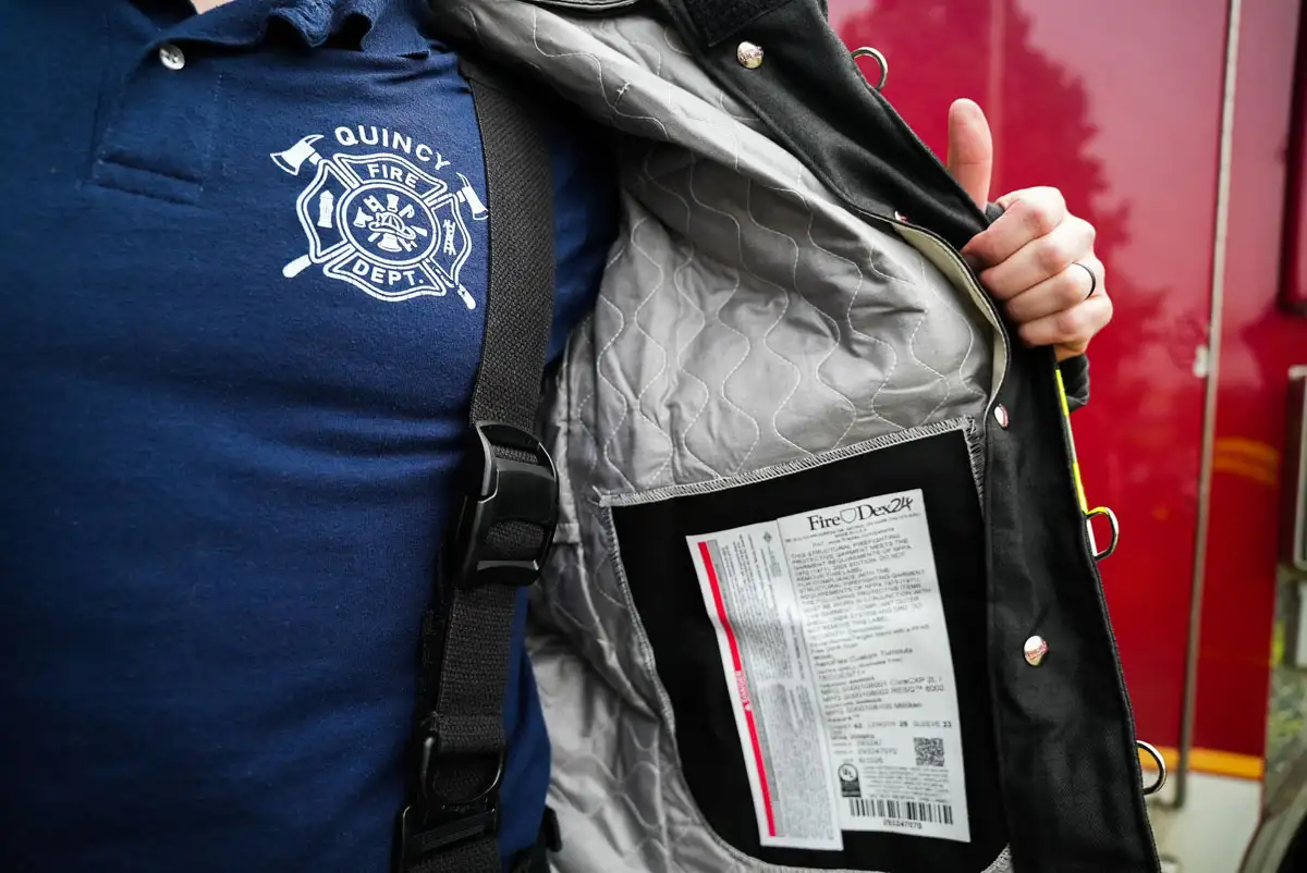 Quincy firefighter showing the label inside of jacket