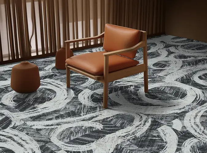 leather chair on organic patterned carpet tile