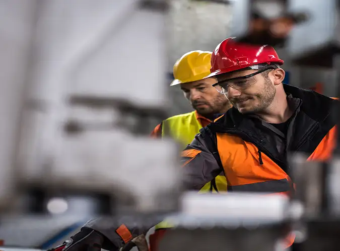 Two workers maintaining machine