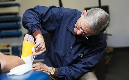 sports trainer applying tape