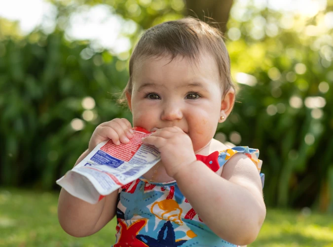 Baby eating bagged fruit