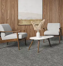 Modern seating area with wood walls and white chairs on Milliken flooring