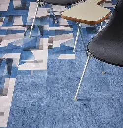 Tight shot of desk and chair in a classrom with blue edge lt carpet tile installed
