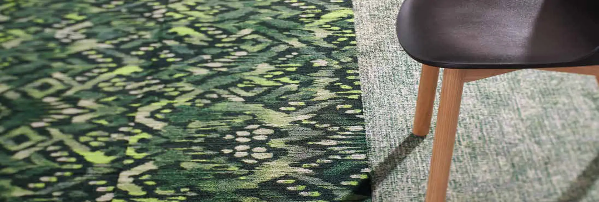 green geometic carpet with a bold pattern next to a textural pattern