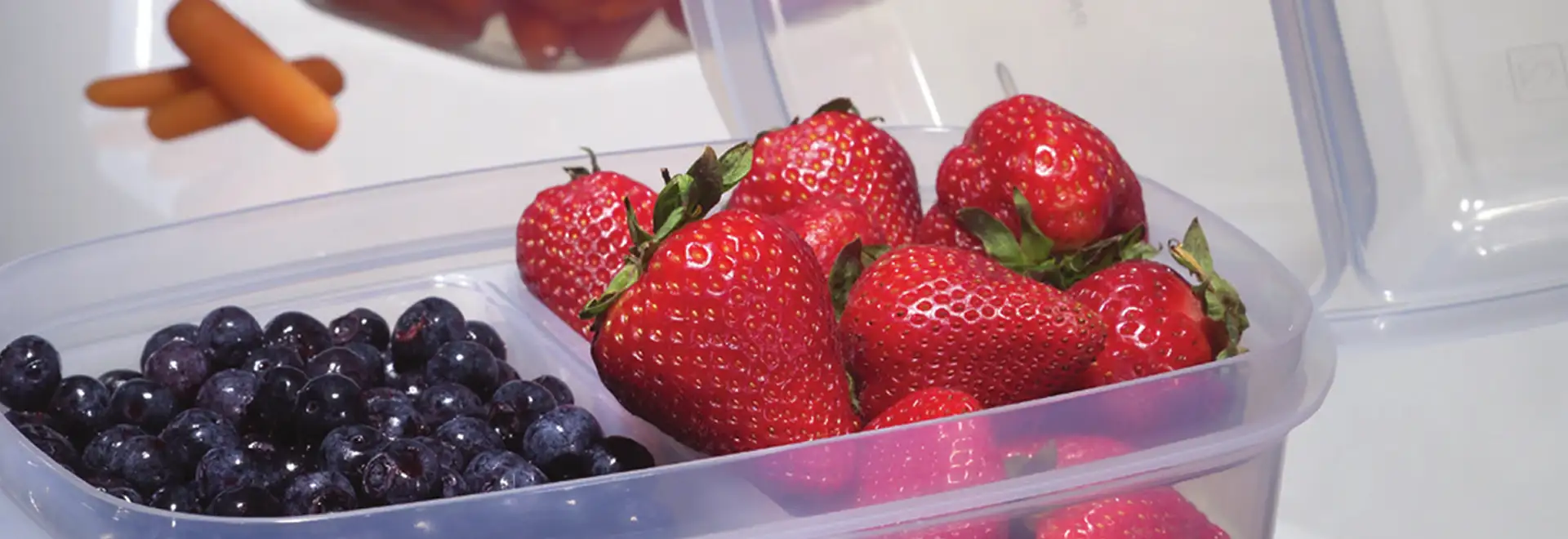 Clear divided food container with Strawberries and blue berries