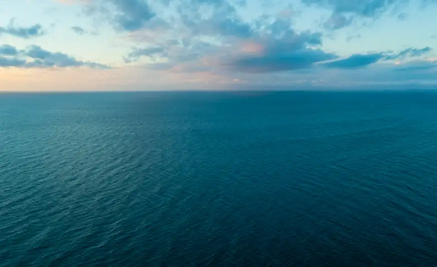 sunrise over blue green body of water
