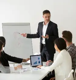 person standing and presenting to a group in a confernce room
