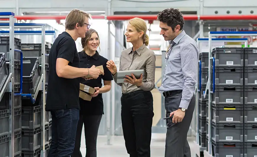 group of people talking and smiling on plant floor