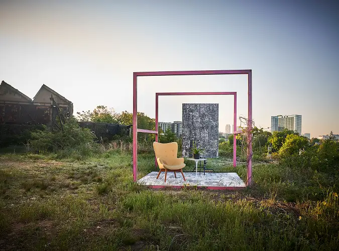 Staged seating area in field with yellow chair and textural carpet tile