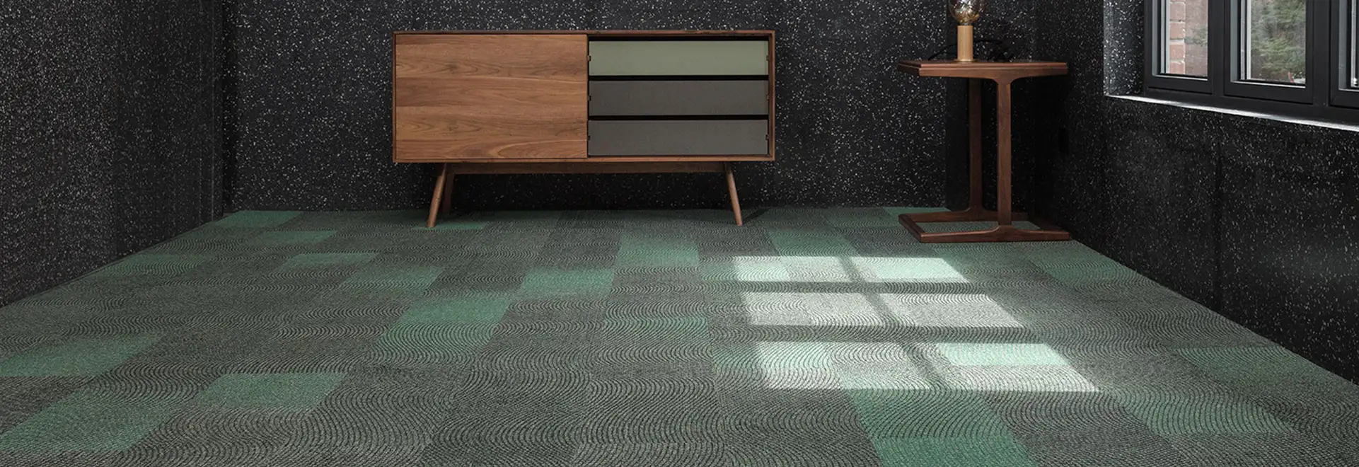 Dark walls and modern credenza with green accents on green carpet tiles