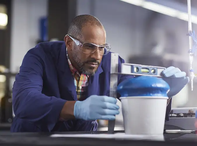 person in saftey gear performing a chemical test