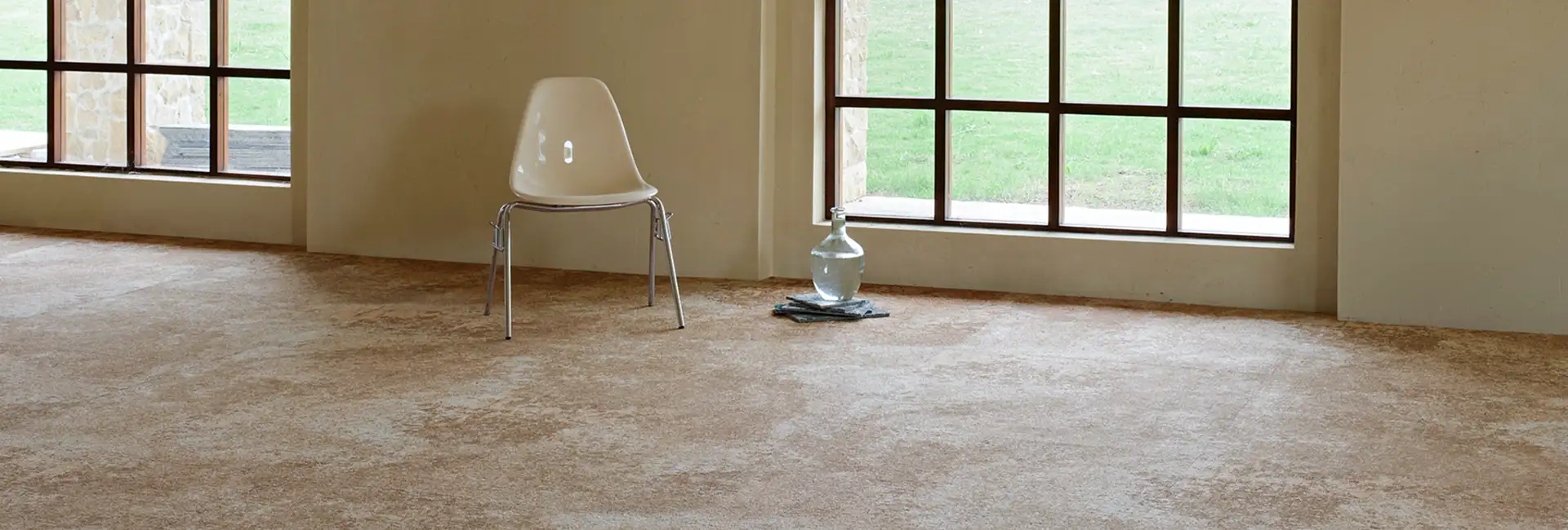 chair and clear glass bottle on tan textural carpet tile