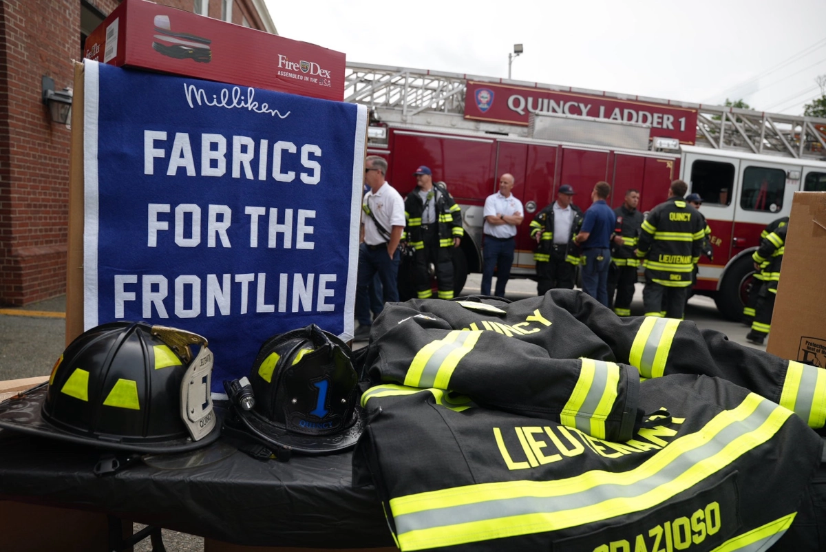 Fire fighter gear and fire fighters in the distance near a fire truck in Quincy, Massachusetts