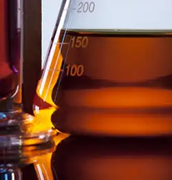 close shot of glass beakers with amber liquid 