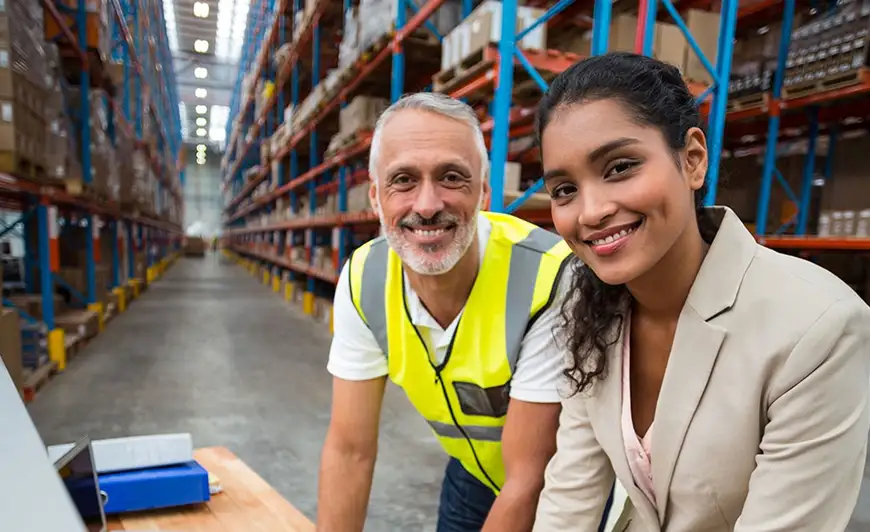 Two smiling people in warehouse
