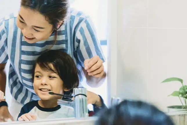 woman and child smiling brushing teeth