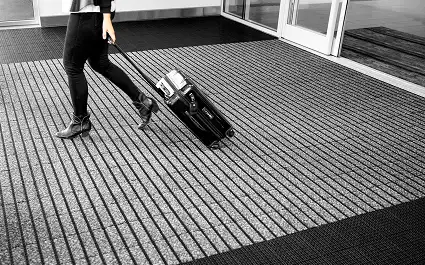 Entrance with person rolling a bag on OBEX Grid flooring