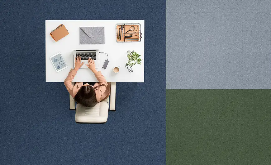 top view of a person at a desk with blue, green and grey carpet tile blocks