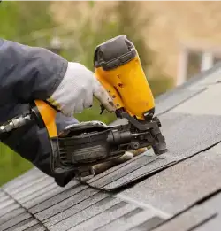 Building and construction roofer nailing shingles