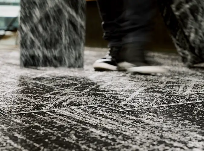 Tight shot of SDN carpet tile with person walking over it