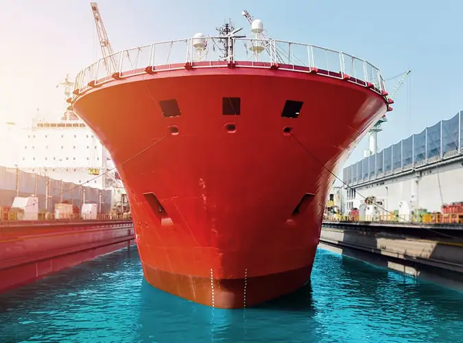 front of a large ship painted red on blue water