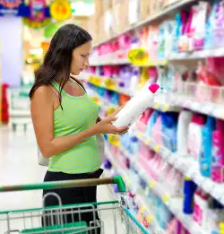person is store looking at bottled cleaners
