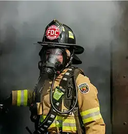 fire fighter in smoke wearing Turnout Gear made of Milliken Fabric