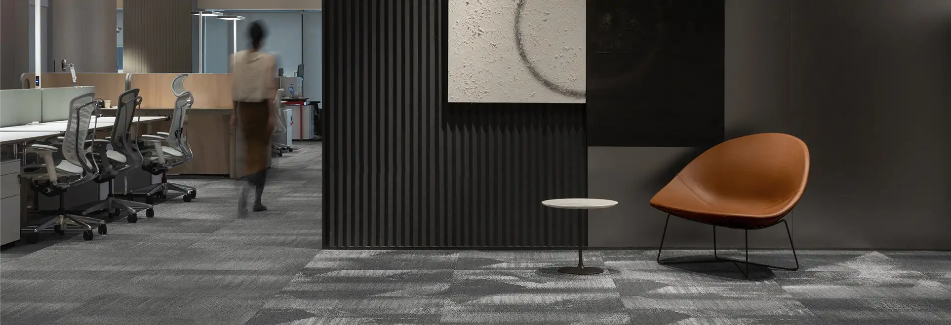 open office with gray flooring and person walking away
