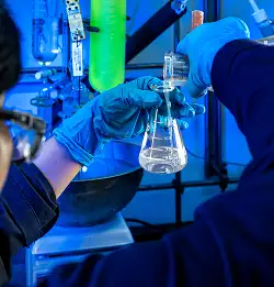 Close up of a chemist holding a beeker