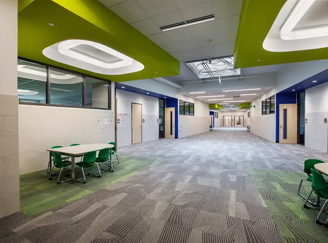 Educational hallway with gray carpet and green insets