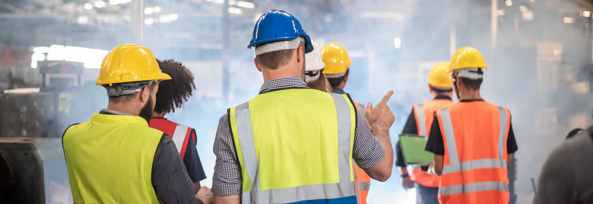 Group of associates from behind all wearing safety gear and hard hats