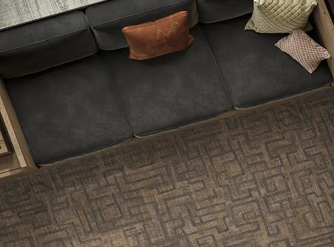 close shot of sofa edge with geometic patterned carpet