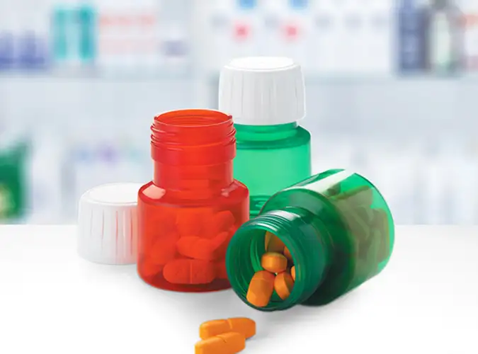 clear medication bottles in red and green