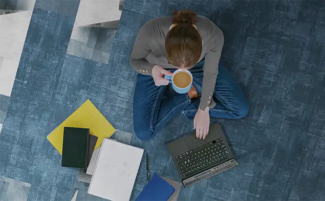 top view of person sitting on carpet tile flooring