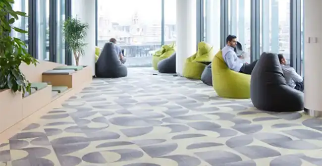 people sitting on modern chairs with a geometric carpet tile design