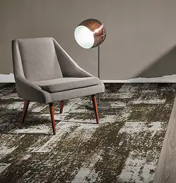 single chair and bronze lamp with textured carpet tile flooring