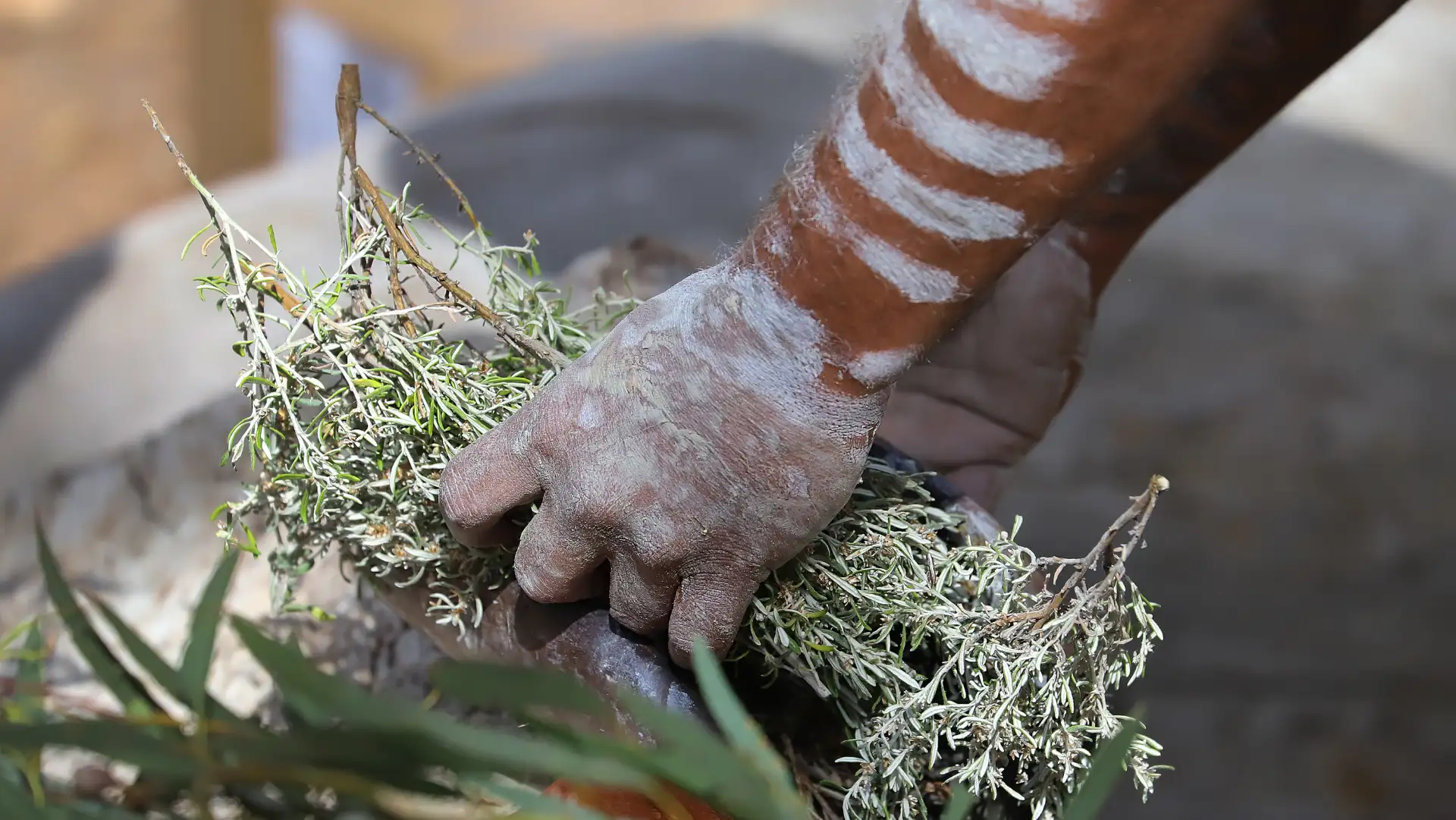 closeup of painted hands with a handful of brushy flora