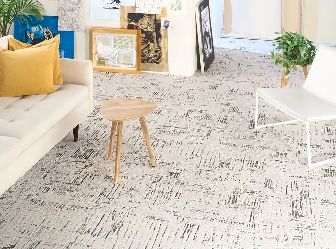 close up of sofa and wooden stool on textural carpet tile
