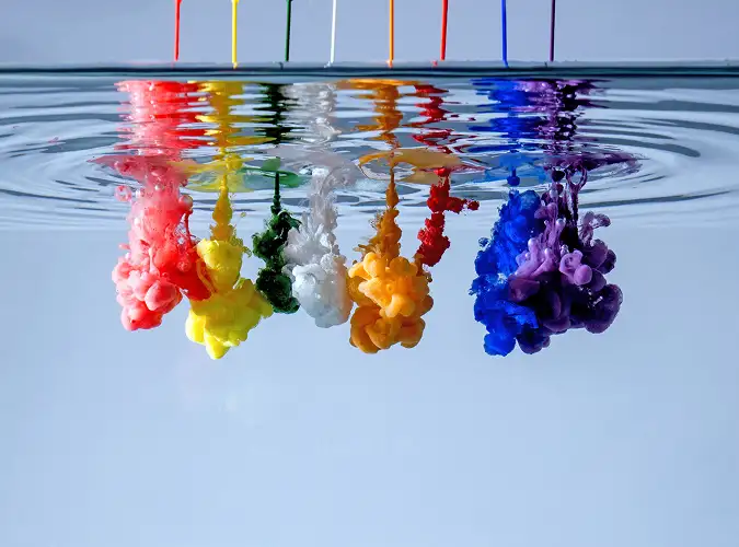 bright colored liquids being poured into clear liquid