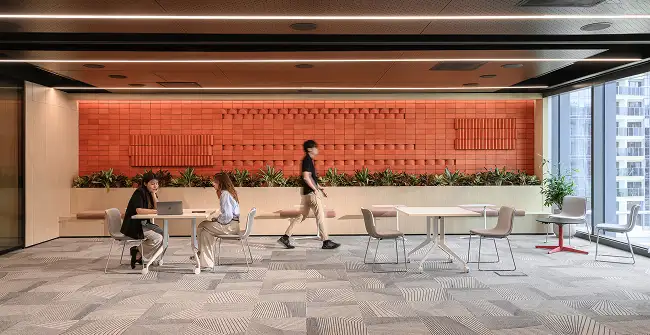 open public space with orange accent wall and Milliken carpet tile flooring