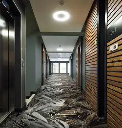 Bold large pattern broadloom carpet in a natural coridoor