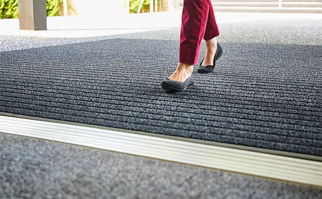 close shot of person wlaking on OBEX Bar entrance flooring